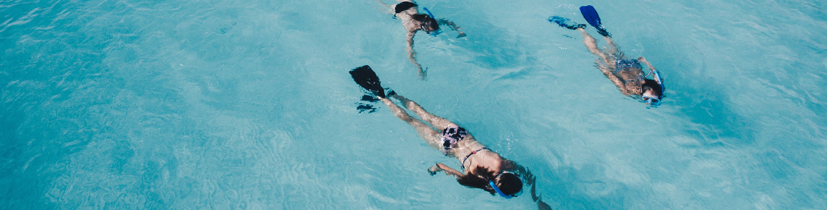 Girls snorkeling in blue waters