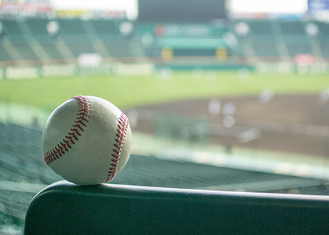 Close up of baseball with stadium in background