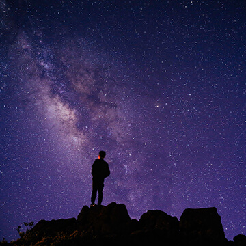 Silhouettes of man stargazing