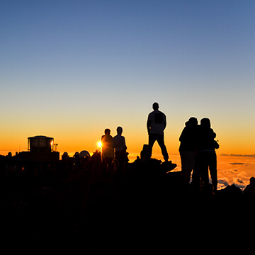 Silhouettes of people watching sun