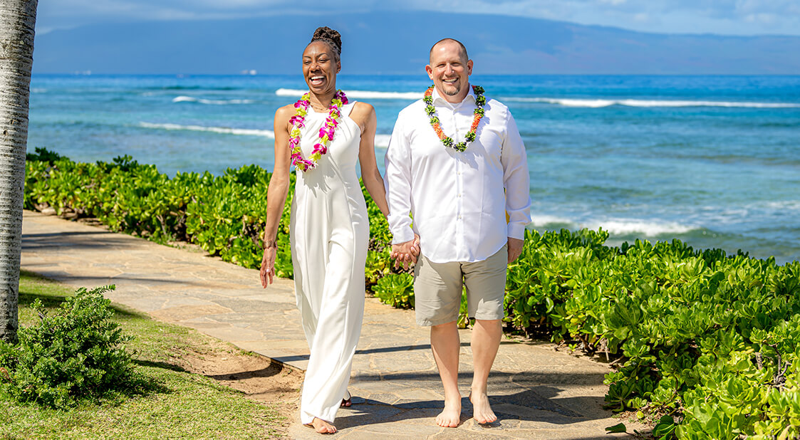 Newlyweds walking along oceanfront lawns