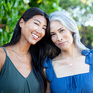 Two women in embrace and smiling.