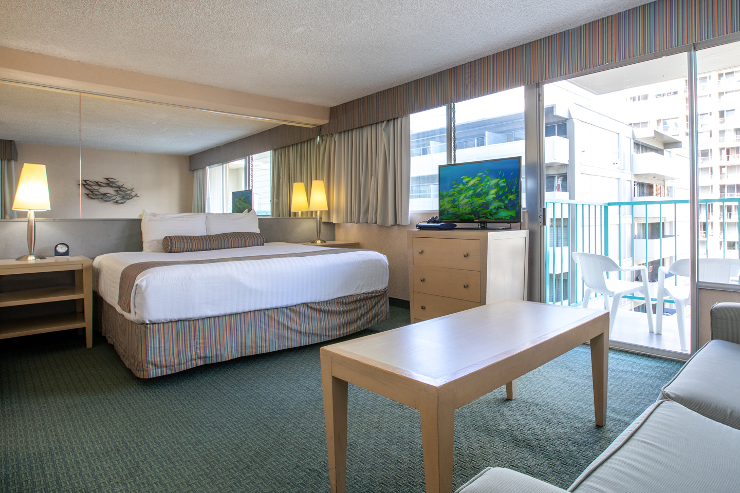 Living area with a bed, coffee table, TV, and balcony.