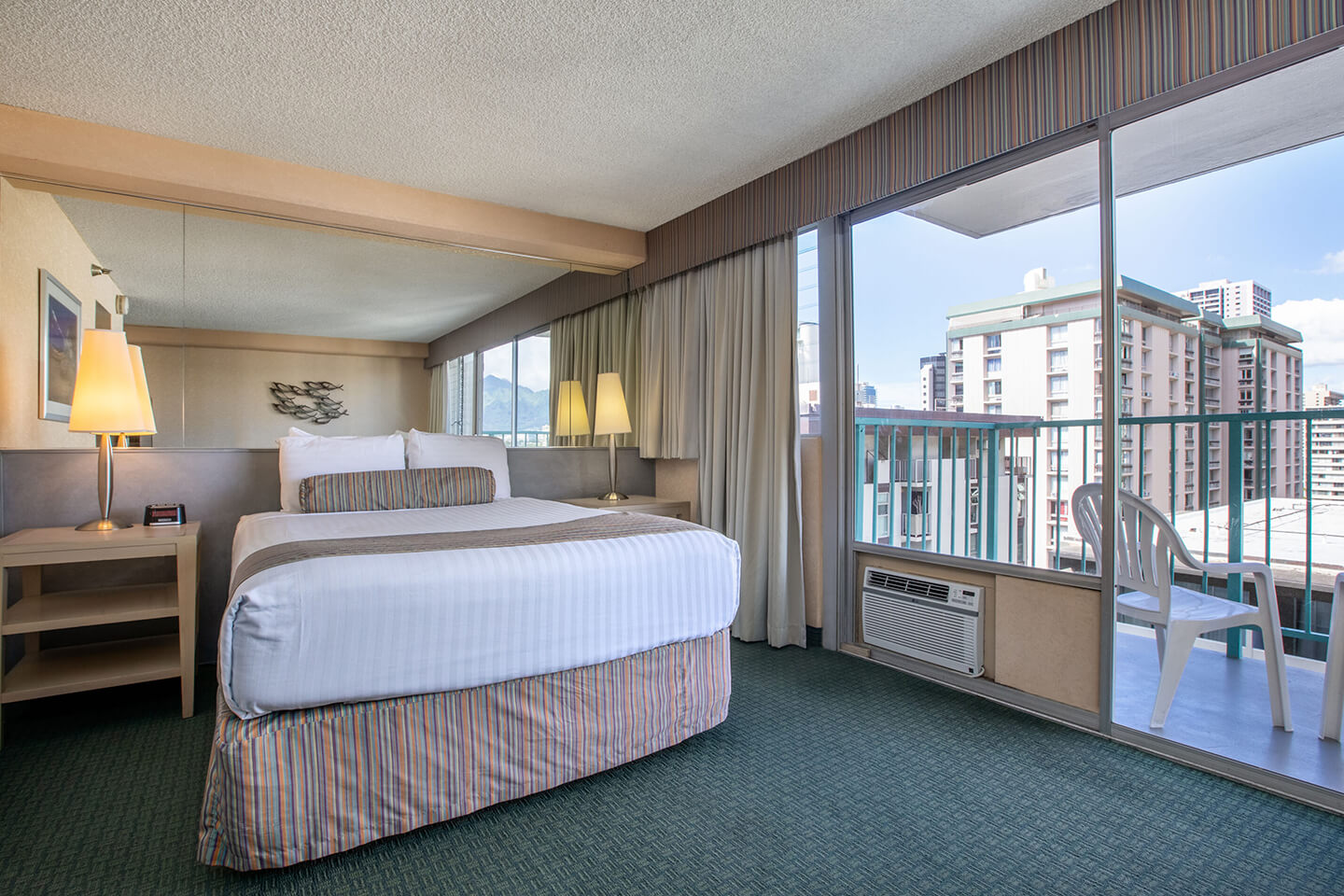 Room with a bed, nightstand, and balcony.