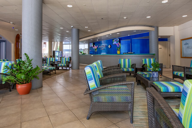 Lobby with front desk, seating, and elevators.