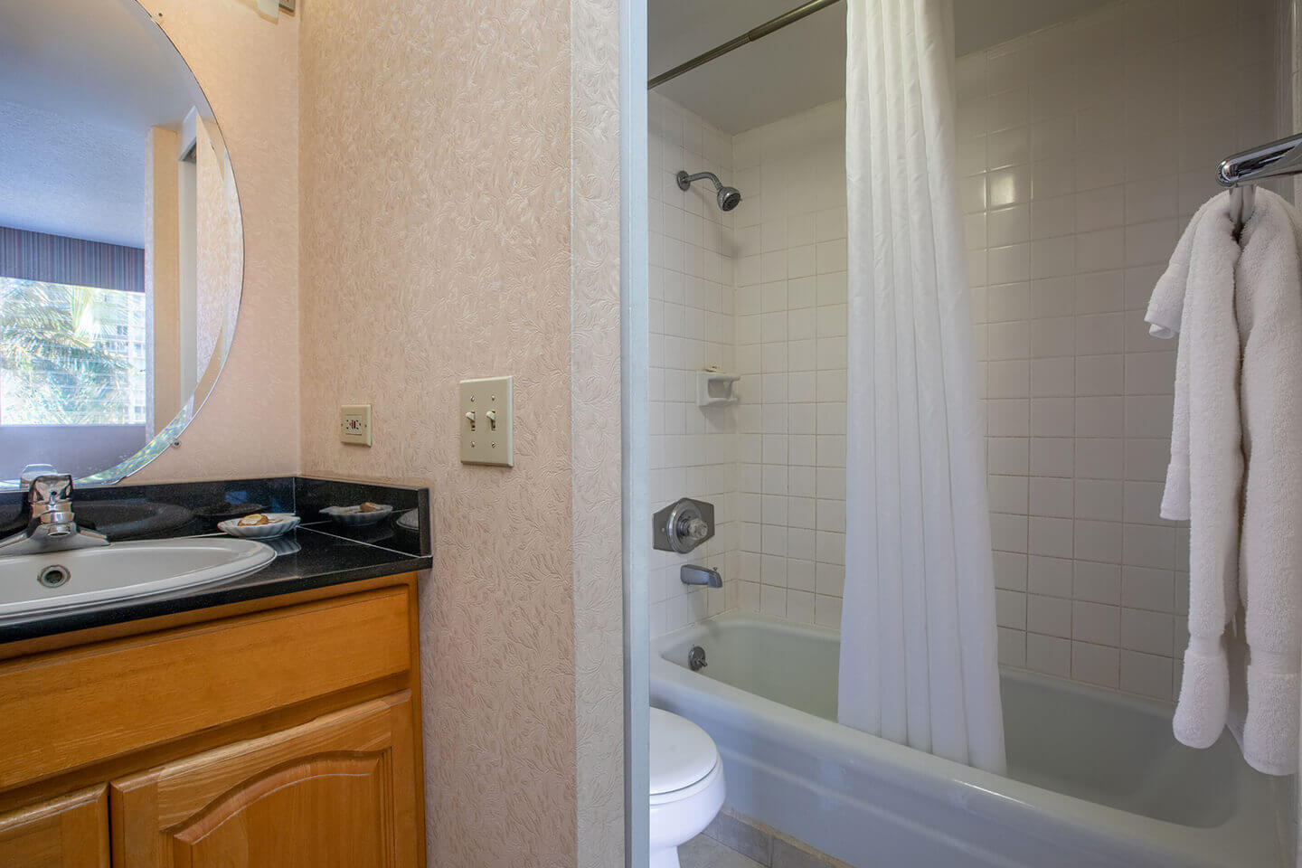 Bathroom with shower/tub combo, sink, toilet, and towels.