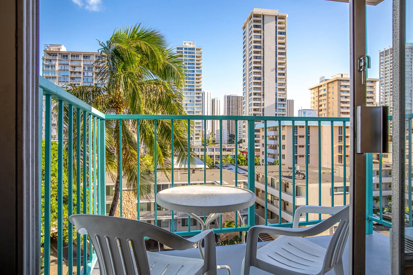 Balcony with two chairs and view overlooking Waikiki. 