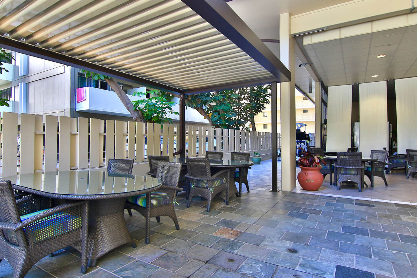Patio area with tables and chairs near pool deck.