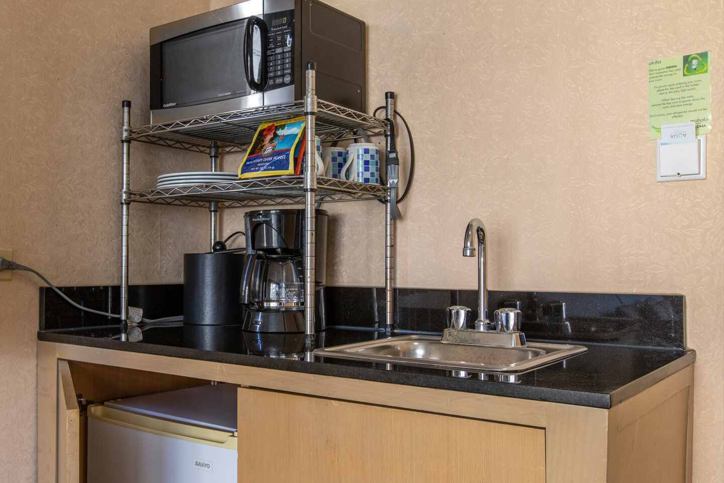 Wet bar with a microwave, coffee maker, and sink.