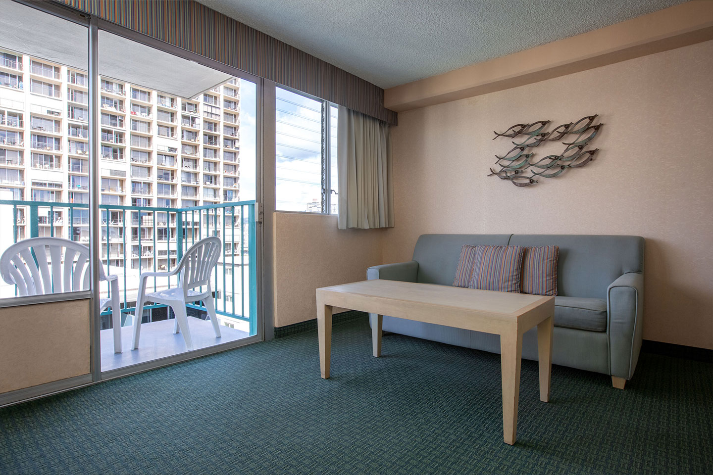 Room with a couch, coffee table, and balcony.