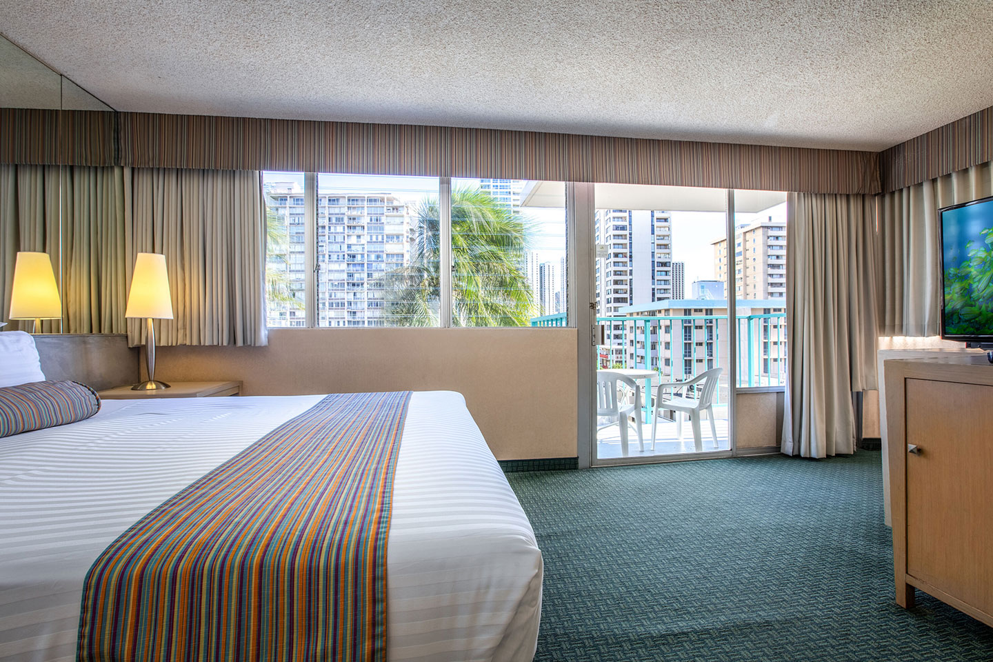 Room with a bed, TV, and balcony.