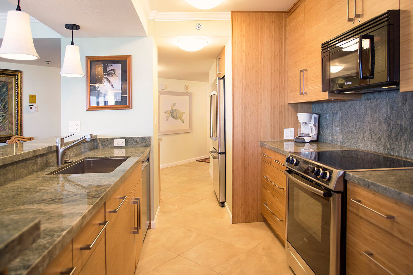 Kitchen with a sink, stove, oven, microwave, and refrigerator.