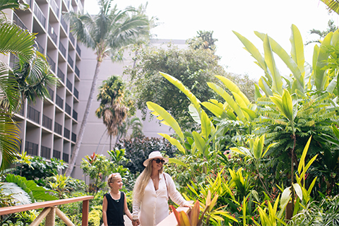 Girl with mother walking through gardens