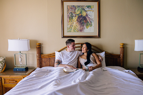 Couple in bed with book and coffee