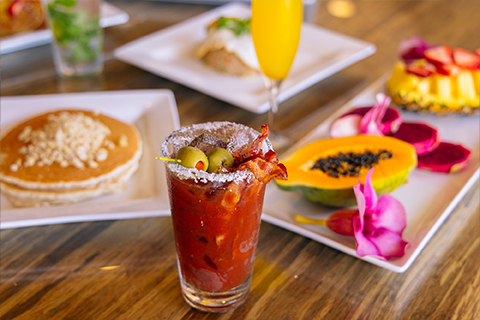 Table with breakfast dishes and bloody mary drink