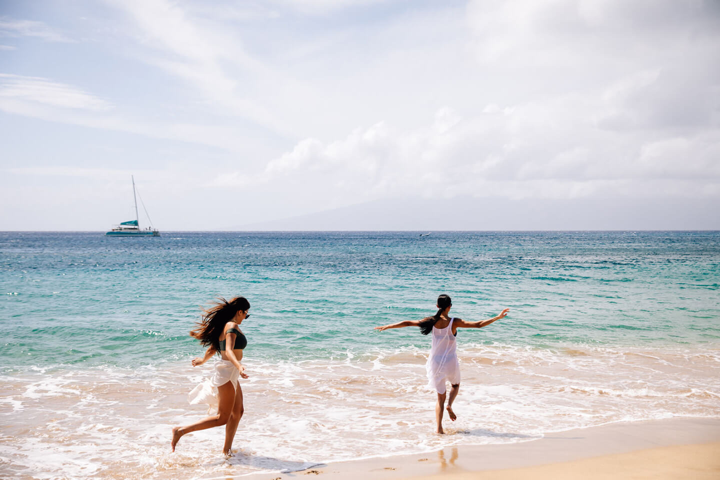 2 women running along beach.