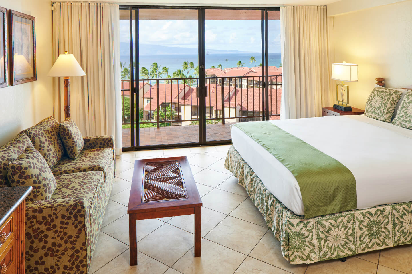 Room with a bed, nightstand, lamps, coffee table, couch, and balcony.
