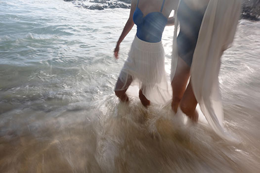 women walking in the ocean at the beach