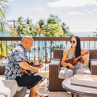 Man and woman playing ukulele