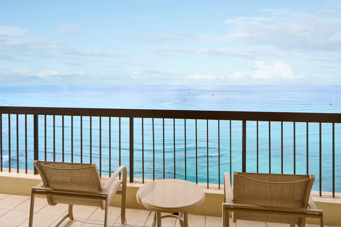 Balcony with table, chairs, oceanfront view.