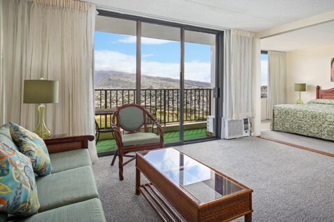 1-Bedroom Deluxe Mountain View living area with sofa, separate bedroom, and view.
