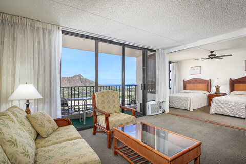 1-Bedroom Deluxe Ocean View living area with sofa, separate bedroom and view.