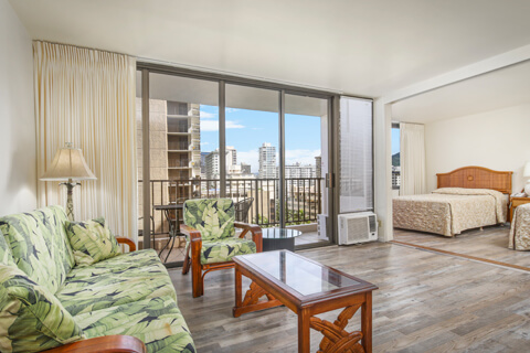 1-Bedroom Standard Suite living area with sofa, separate bedroom and view.