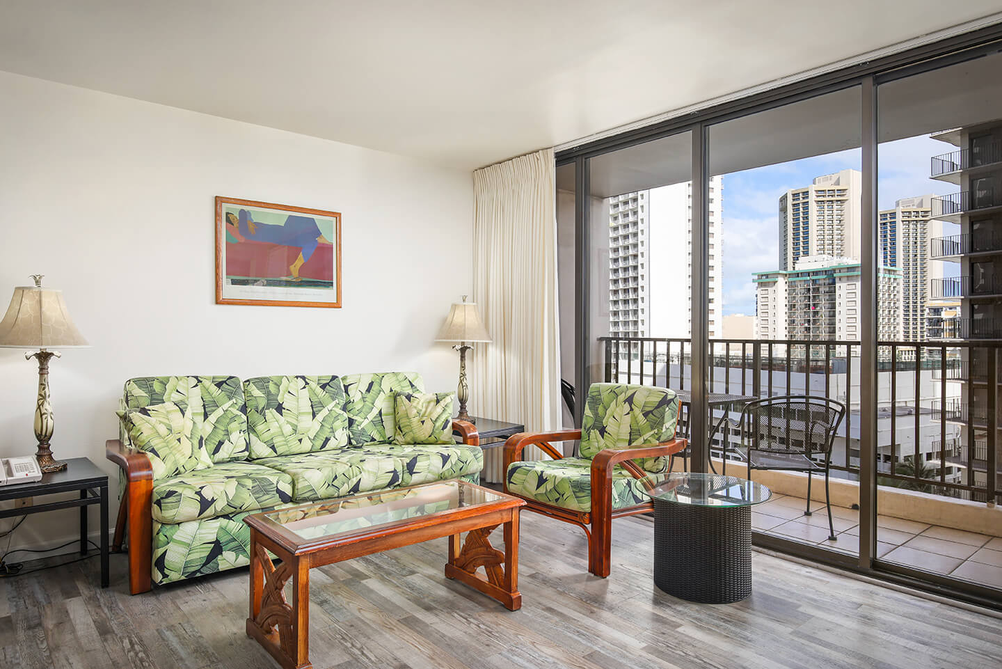 1-Bedroom Standard suite living area with a sofa and private balcony.