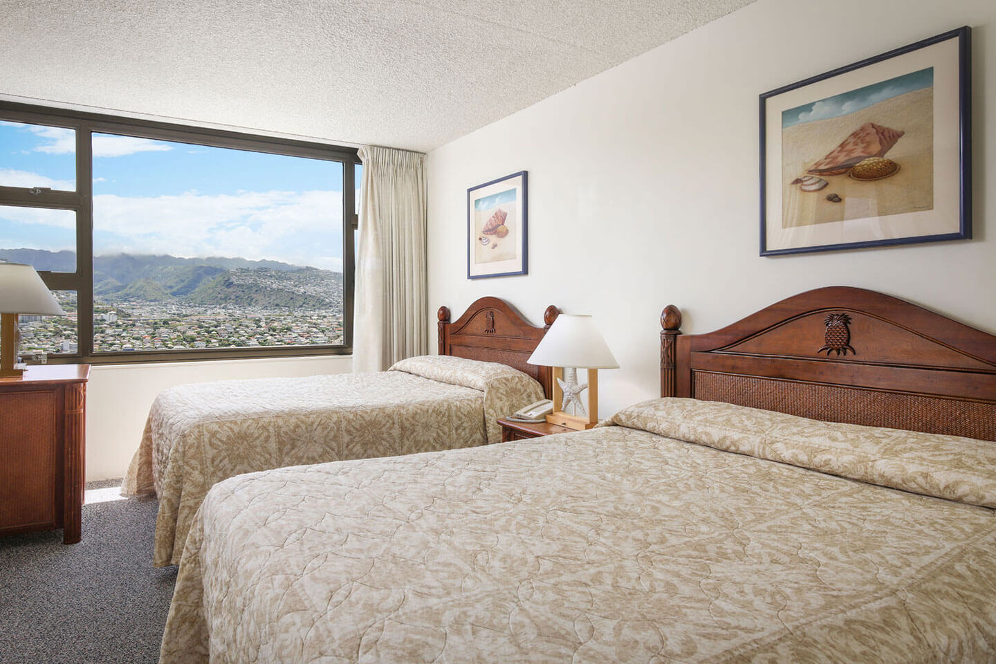 Room with 2 beds and large picture windw with mountain view.
