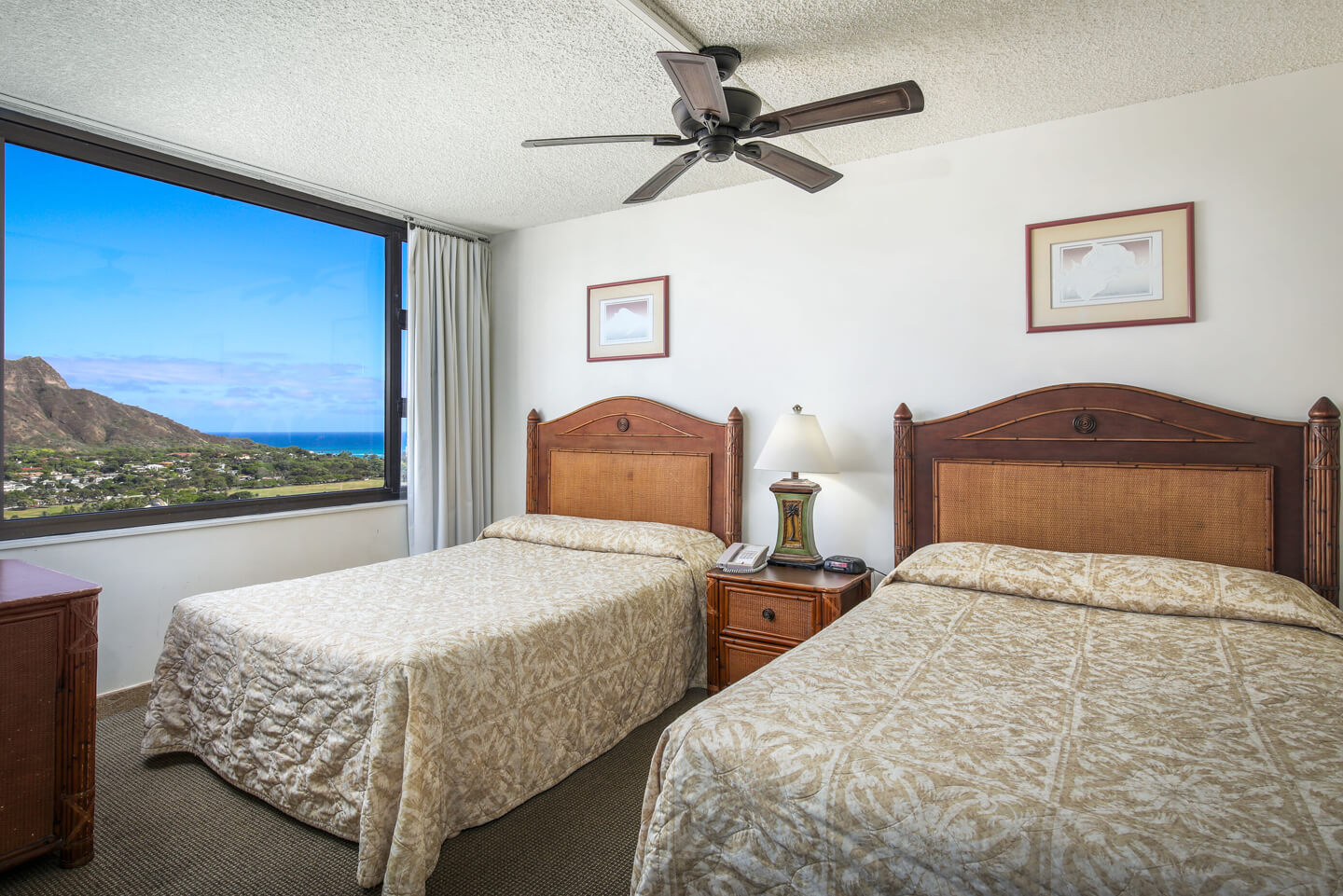 1-Bedroom Deluxe Ocean View bedroom with twin beds and window view.