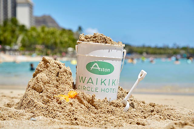 Hotel logo sand bucket and shovel in sand