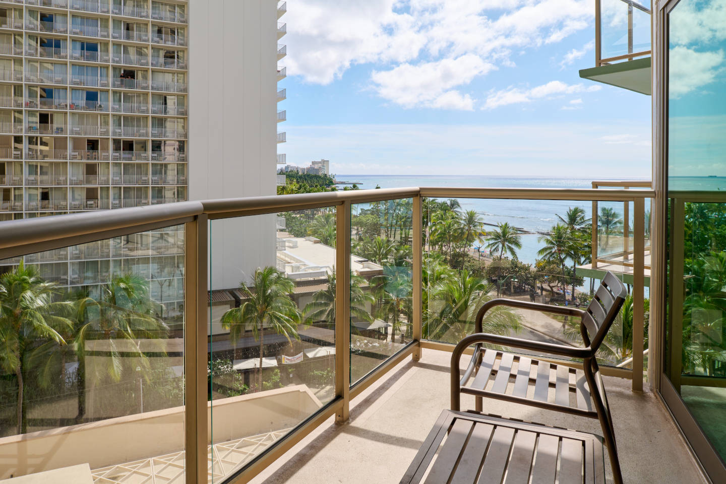 Balcony with a table, chair, and ocean view.