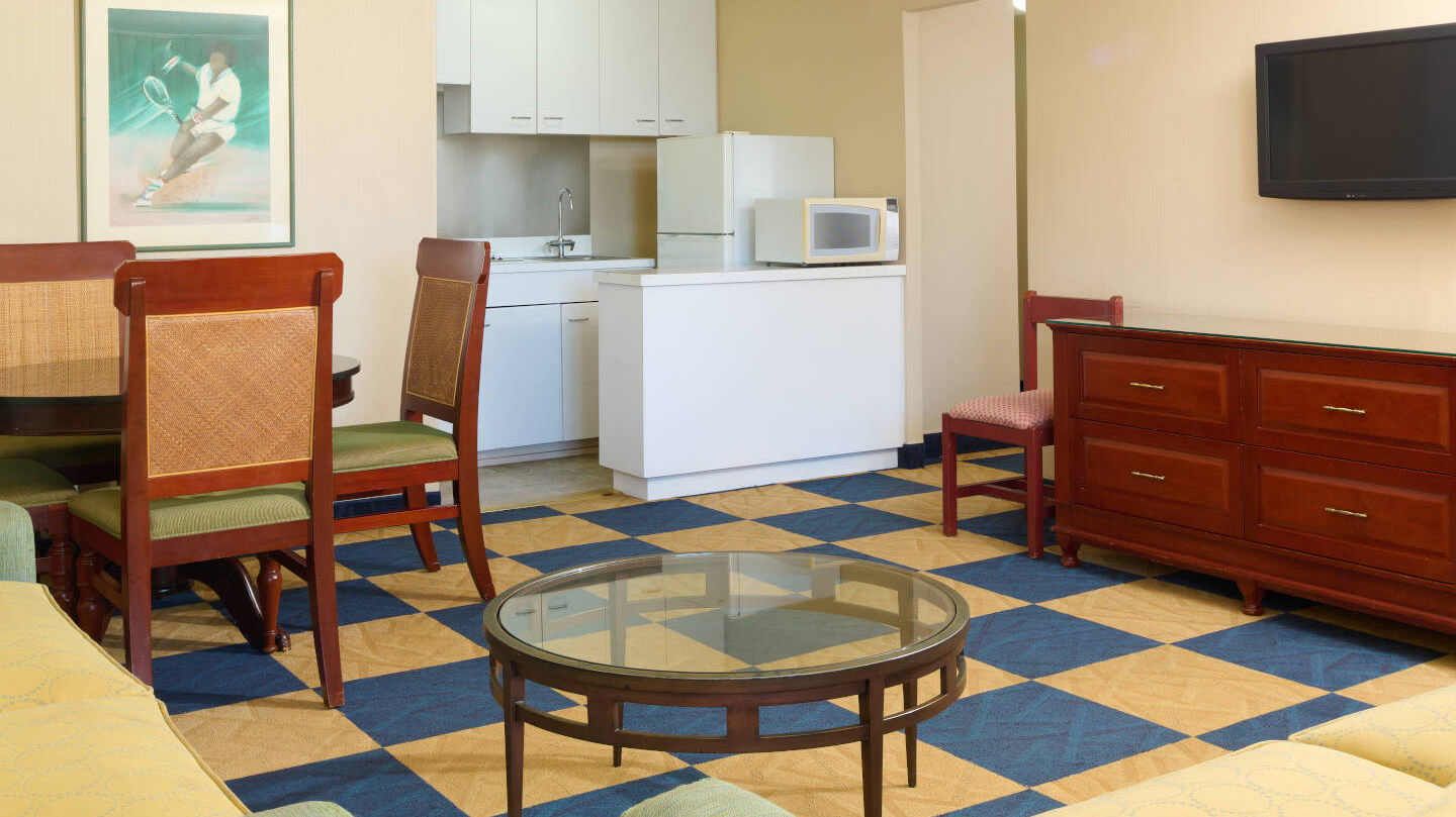 Room with dining area, coffee table, dresser, TV, and kitchen.