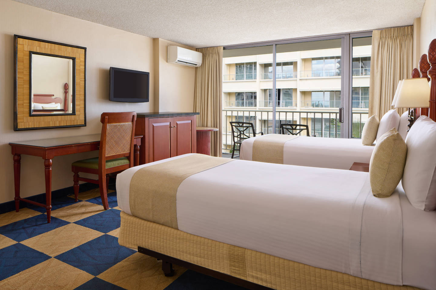 Room with 2 beds, nightstand, lamps, dresser, TV, desk, and balcony.