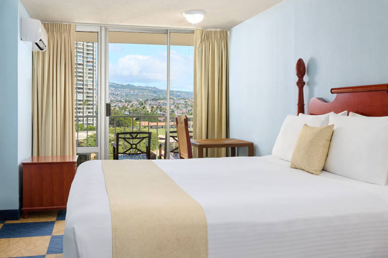 Master bedroom in the Penthouse with king bed, dresser, and beautiful views from the balcony 