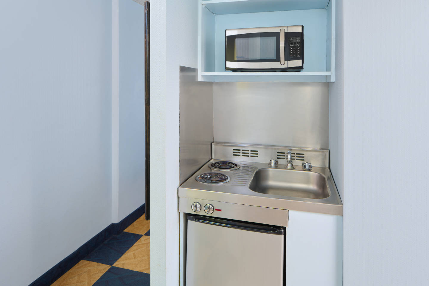 Kitchenette with a microwave, sink, and stovetop.