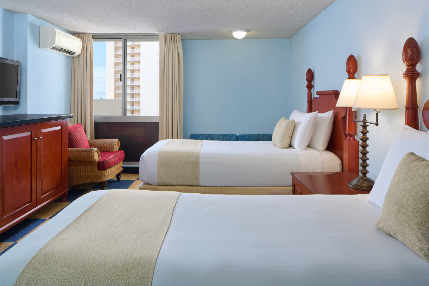 Room with 2 beds, and TV, lamps.