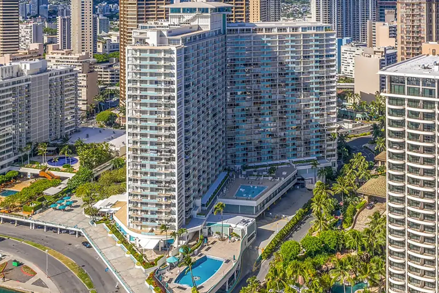 Aerial view of hotel exterior, surroungin area, beachfront, and Diamond Head in distance.