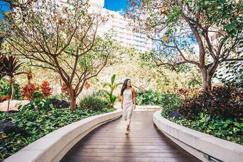 Woman walking through courtyard garden.