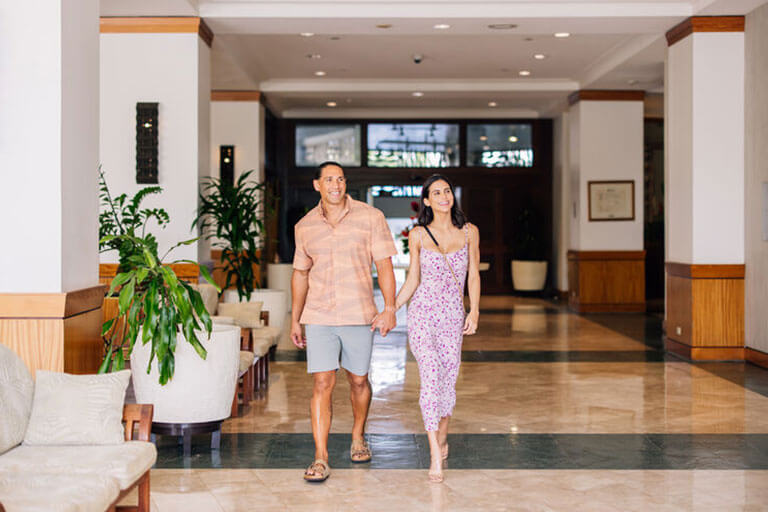 Couple walk through hotel lobby.