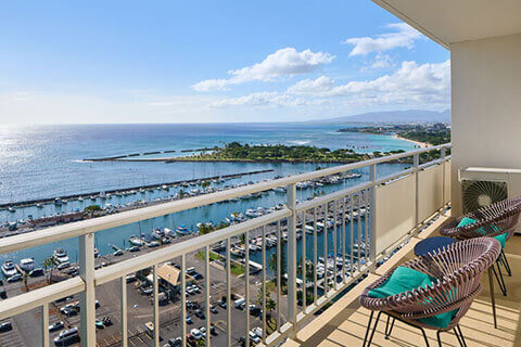 Balcony with table, chairs, ocean view.