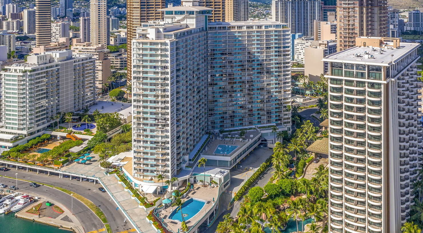 Aerial view of hotel exterior, surroungin area, beachfront, and Diamond Head in distance.