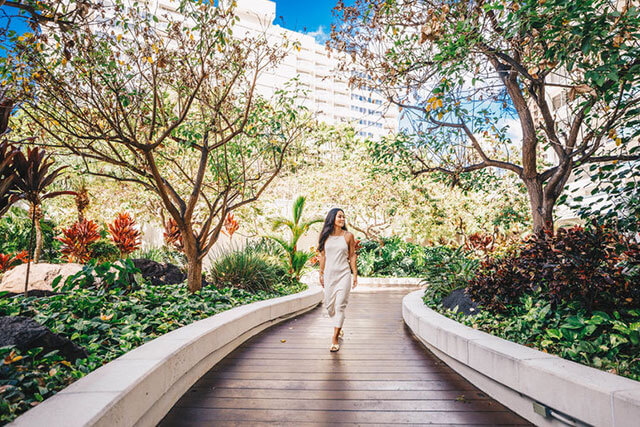 Woman walking through hotel courtyard.