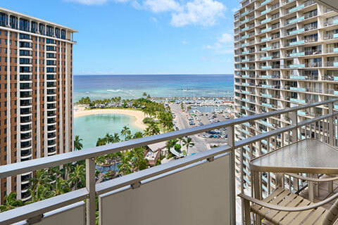 Balcony with table, chairs, ocean view.