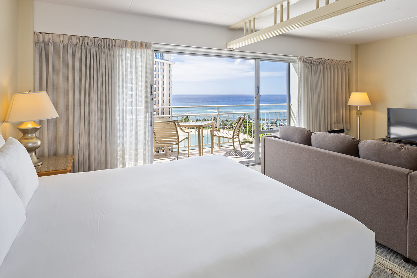 Ocean View Suite Bedroom with king bed, private balcony, and a separate seating area