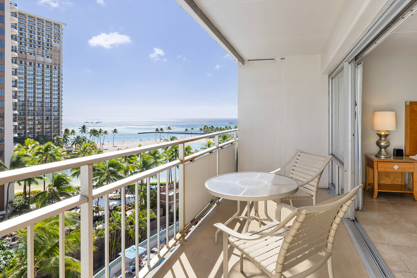 Balcony with table, chairs, ocean view.