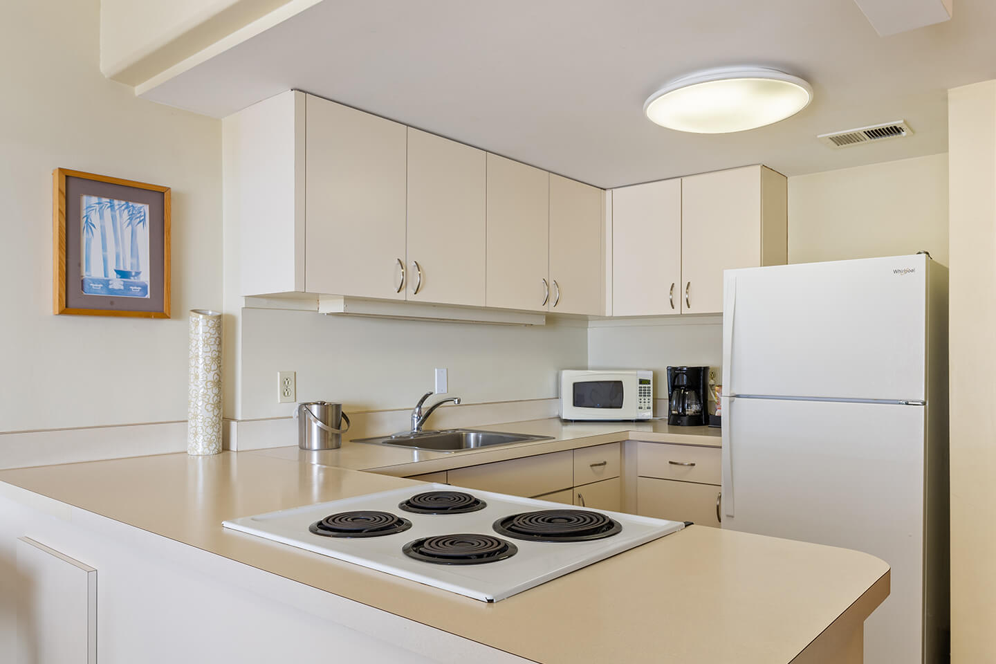 Ilikai LIte Ocean View Jr Suite with full kitchen with a 4-burner stovetop, microwave, other appliances, and refrigerator 