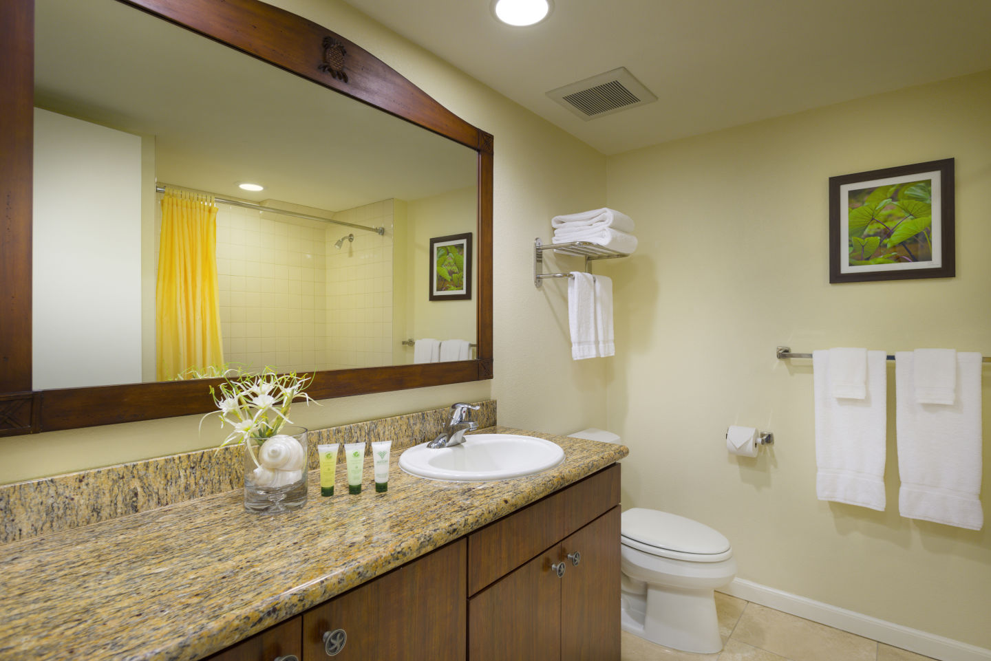 Bathroom with a large mirror and marble countertop at the Aston Islander on the Beach 