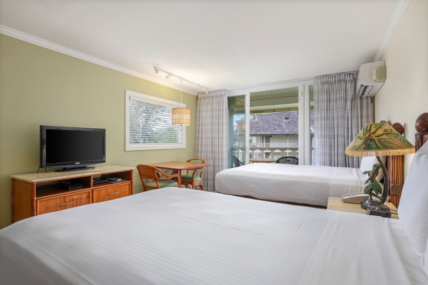 Room with 2 beds, night stand, lamps, dining area, TV, and balcony.
