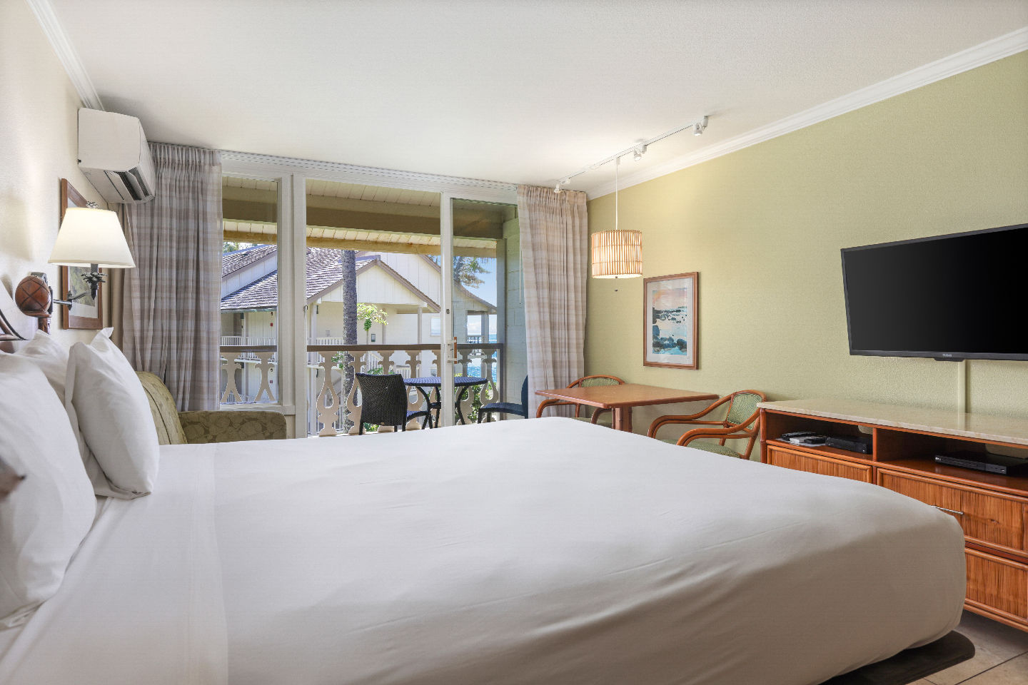 Room with a bed, night stand, lamps, couch, TV, and balcony.